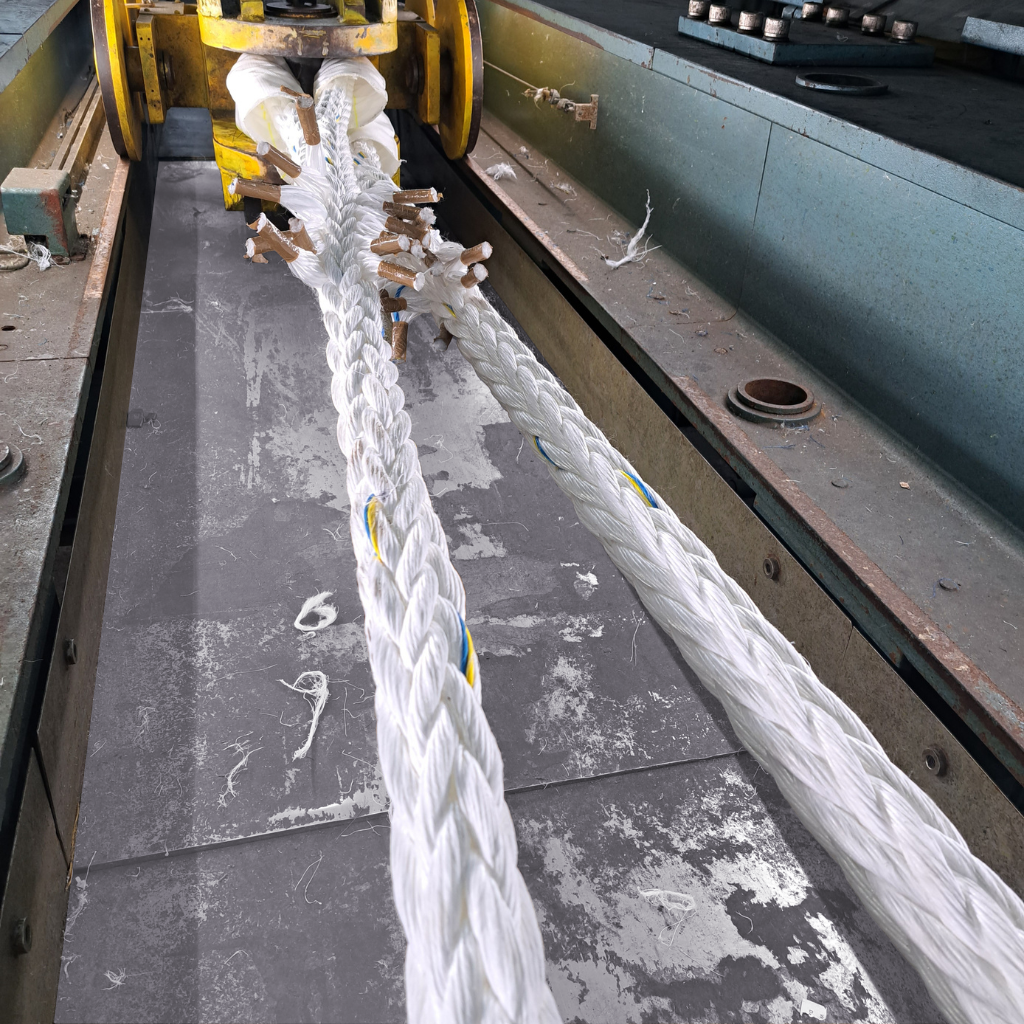 Synthetic mooring rope undergoing tensile break test at Katradis S.A. facility, showing fiber failure at maximum load.