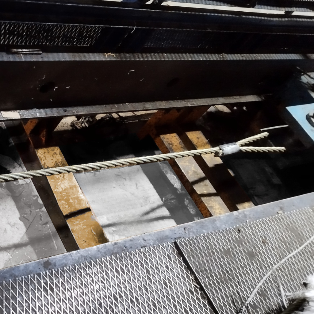 Wire rope sample mounted in a tensile testing machine at Katradis S.A. facility for strength and compliance evaluation.