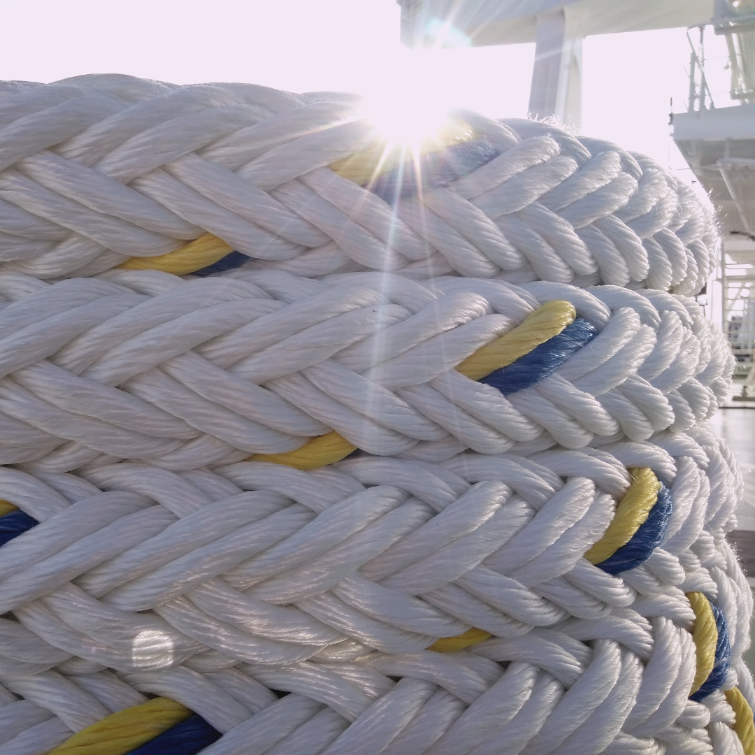 Close-up of UV-stabilized synthetic rope with sunlight flare in the background on ship deck